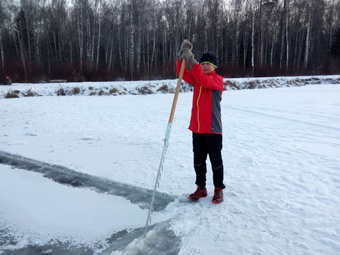 юный "морж" помогает пилить прорубь в национальном парке "Лосиный Остров" (Москва)